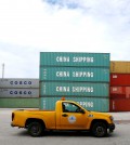 A truck drives past China Shipping and Cosco shipping containers in the Port of Miami in Miami