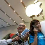 Customers pose with their new Apple's iPhone 7 after purchasing them at the Apple Store at Tokyo's Omotesando shopping district