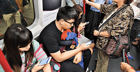 以往大眾乘車多是看報紙或睡覺，現在卻換成了玩手機。（資料圖片）