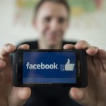 Max Schrems displays a logo of social platform Facebook with his smartphone during an interview with AFP in Vienna, Austria on April 07, 2015.The Austrian law graduate spearheading a class action suit against Facebook for alleged privacy breaches said ahead of the first hearing on April 9, 2015 he hopes the case will eventually lead to an overhaul of a "Wild West" approach to data protection. AFP PHOTO / JOE KLAMAR