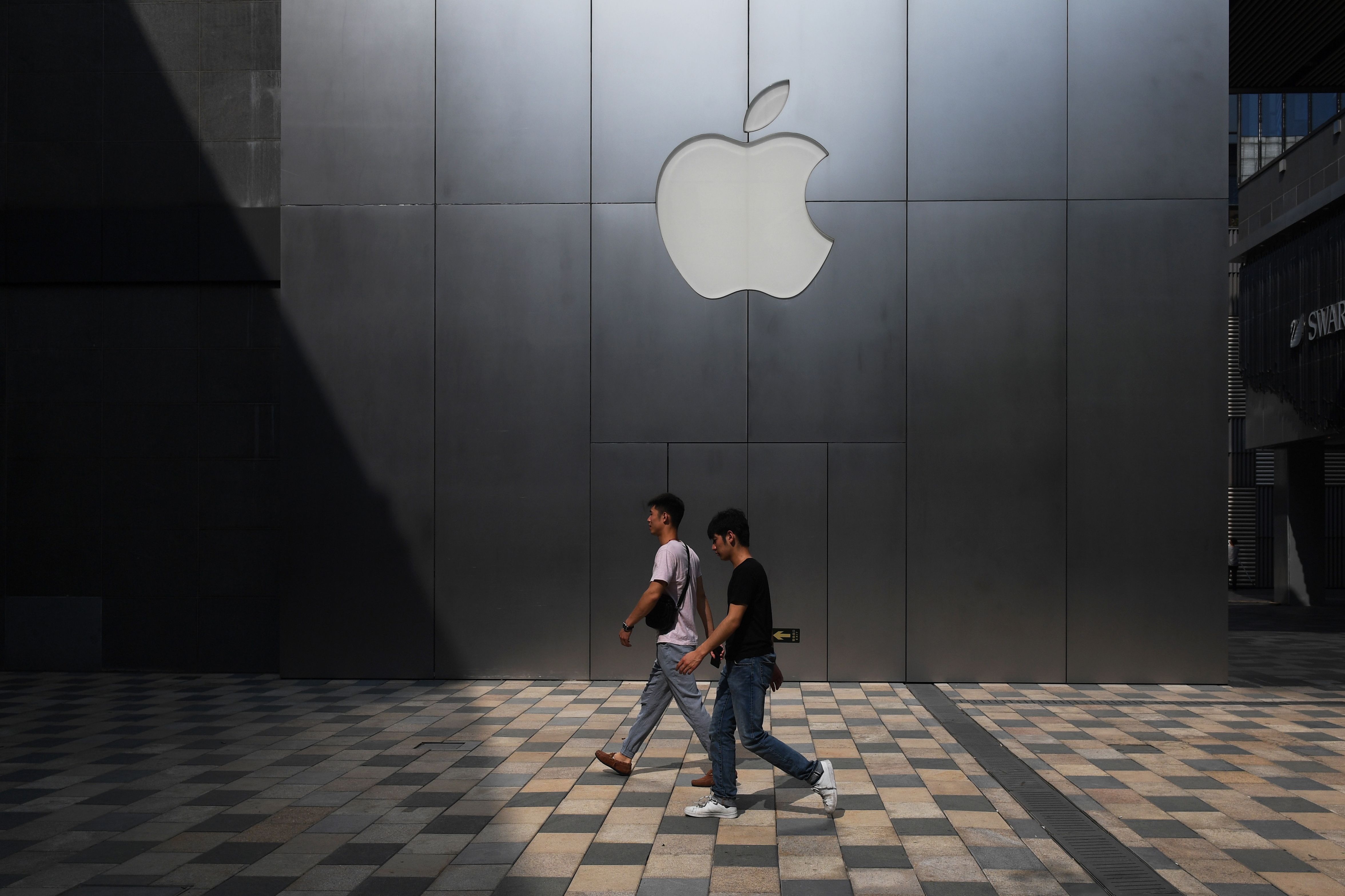This photo taken on August 3, 2017 shows people walking past an Apple store in Beijing. Enterprising internet users in China fear the tools they use to tunnel through the country's "Great Firewall" may soon disappear, as Beijing tightens its grip on the web. / AFP PHOTO / GREG BAKER / TO GO WITH China-IT-censorship,FOCUS