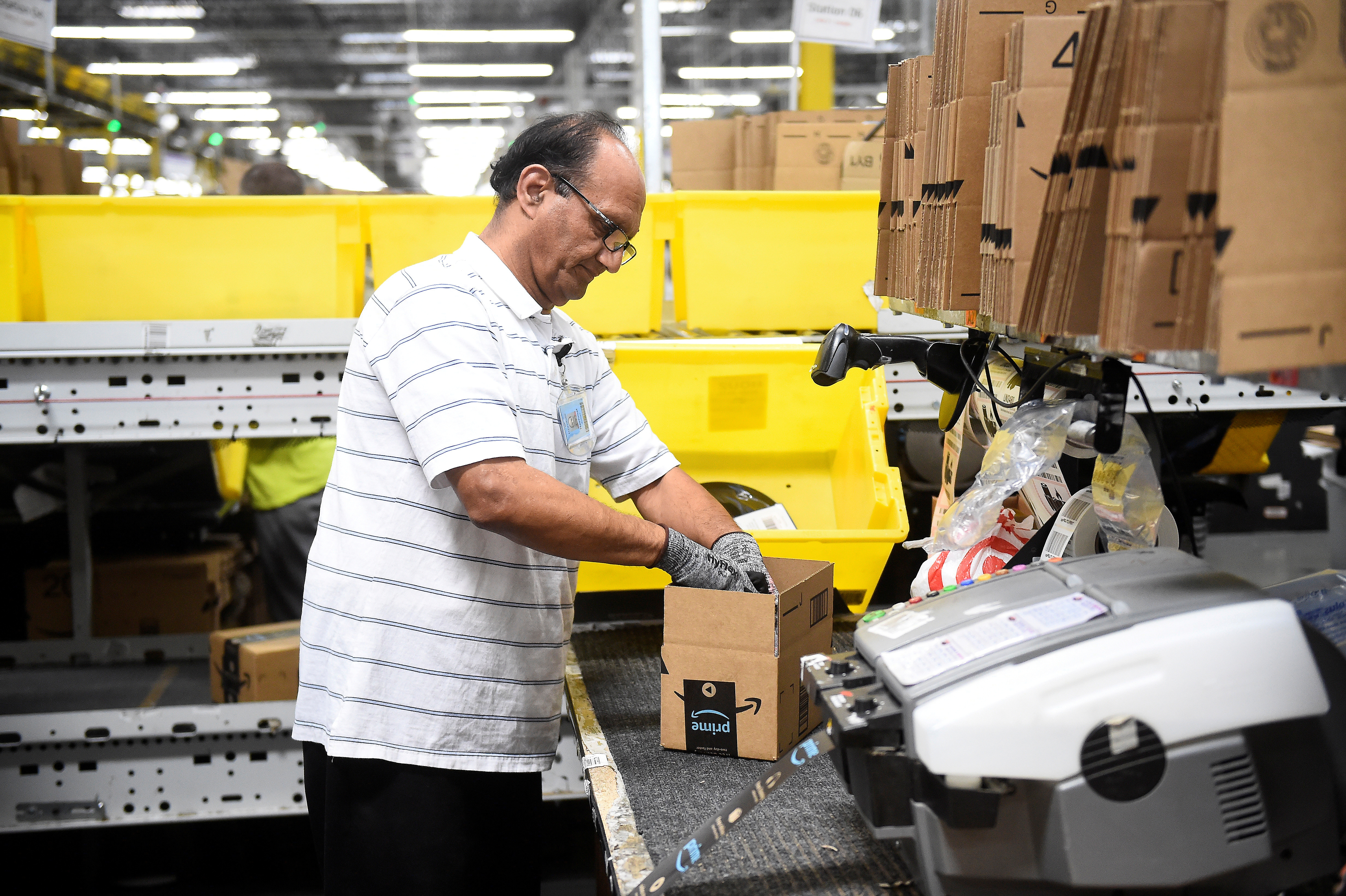 亞馬遜近年採自動化策略，例如以機器取代人手將貨物封箱。（路透社圖片）