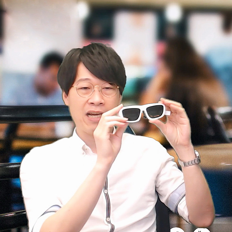 鄭文輝拿着最新研發的第四代混合實境智能眼鏡，重量僅73克。（影片擷圖）
