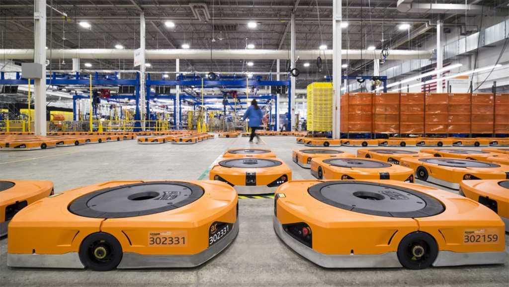 亞馬遜的「無人貨倉」只須小量人類員工管理「搬貨機械車」（前），省時高效。（網上圖片）