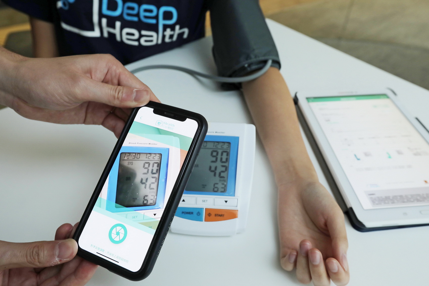 用戶透過手機程式HealthCap拍照，即可記錄血壓計上讀數，並整合成圖表報告。（黃俊耀攝）