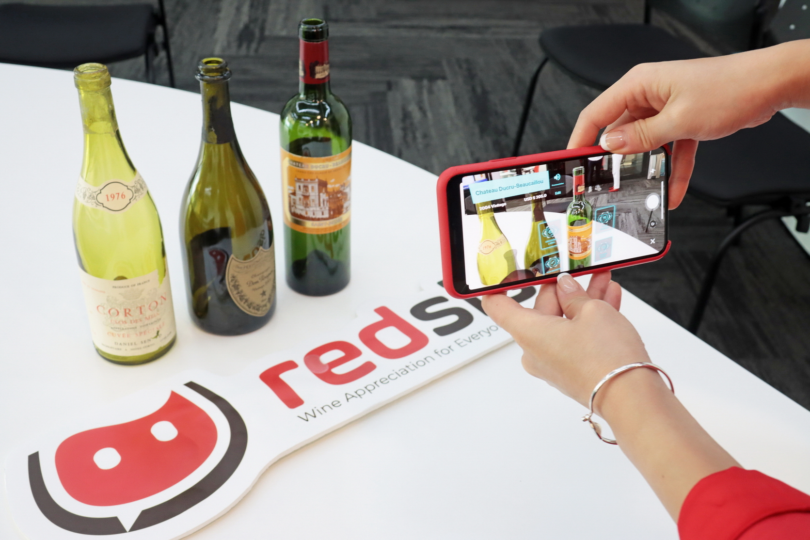 用戶只要以程式掃描瓶身，手機隨即浮現不同AR選項，提供酒食配搭等資訊。（何澤攝）