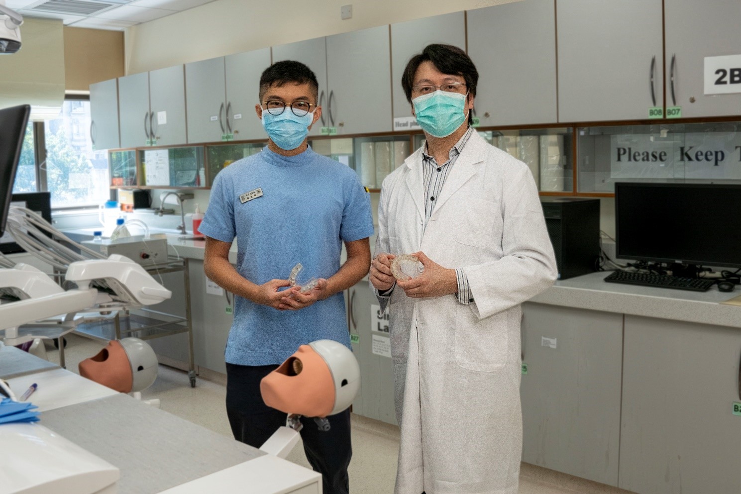 香港大學牙醫學院牙科物質助理教授徐傑漢博士（右） 與學生研究助理陳家輝，共同研發以三維打印技術，度身訂製微霧噴射口部裝置。（港大圖片）