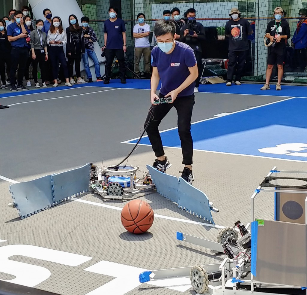 兩個機械人正為爭奪球場上的一個籃球，各出其謀。