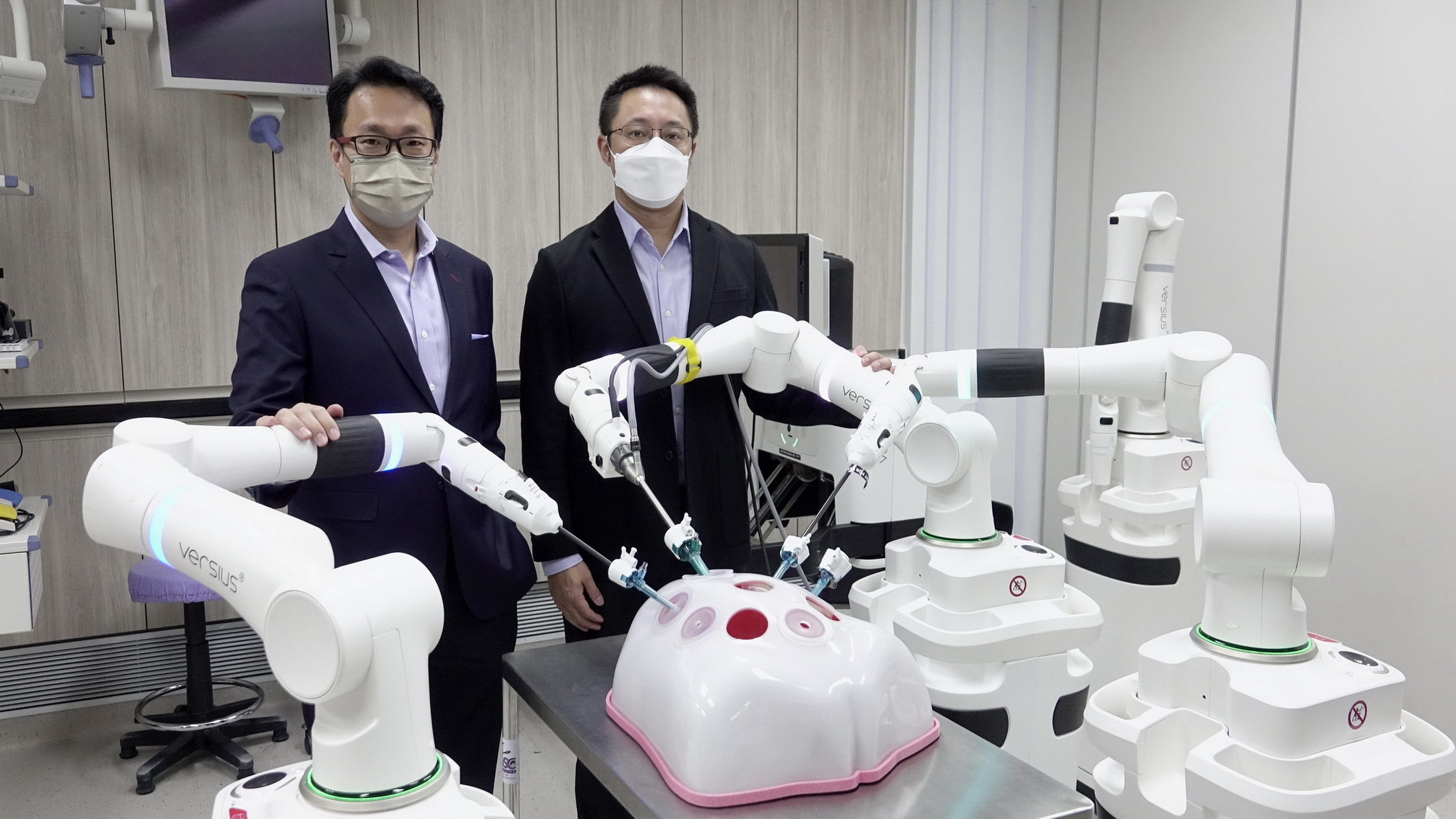 陳展昭（右）表示，機械人系統Versius主要由控制台及機械臂組成，並可提供三維影像；旁為CMR Surgical商務部總經理（遠東區）張健。（盧詠賢攝）