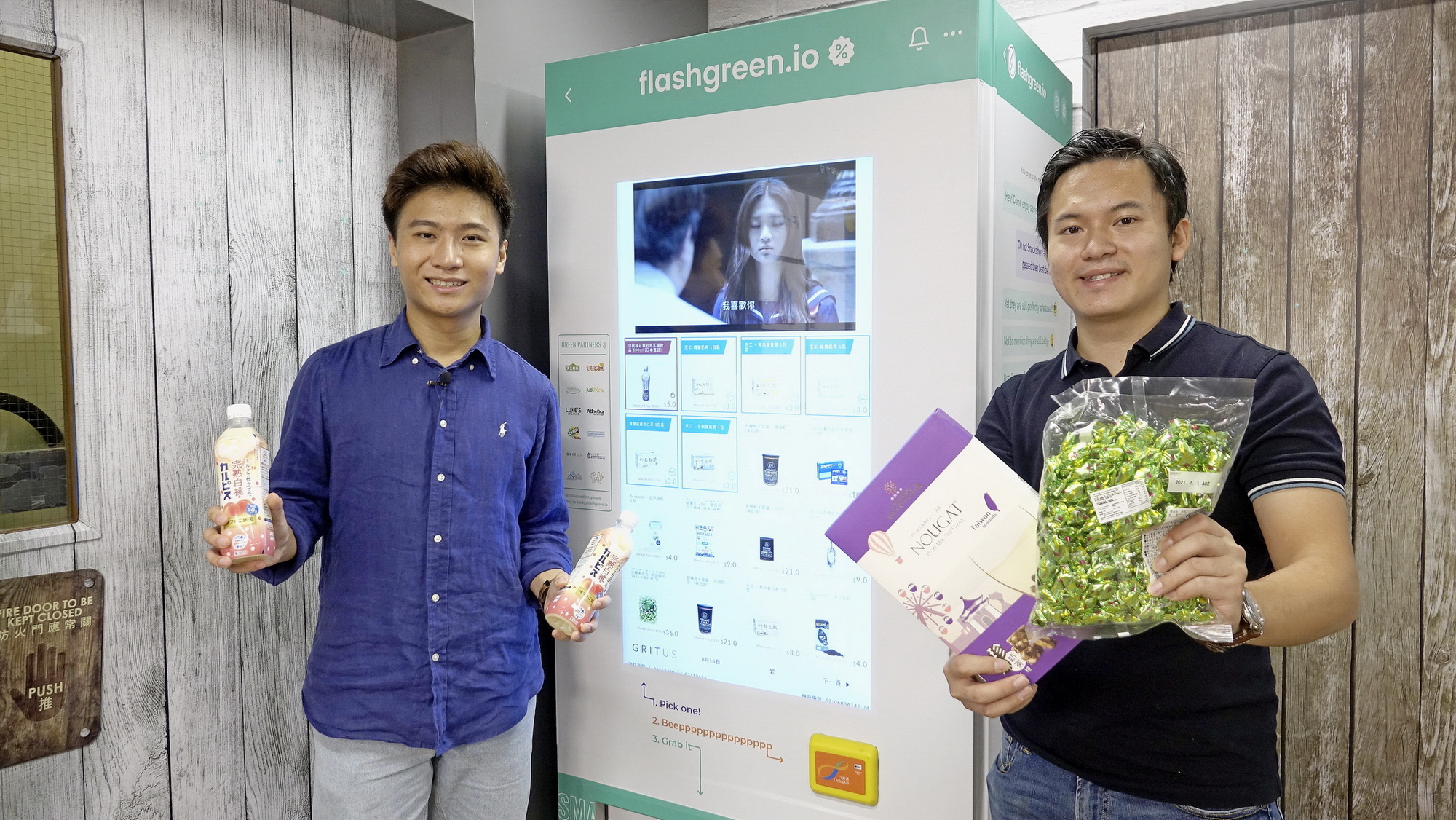 陳俊堅（左）表示，消費者可藉手機程式向自動售賣機預留食品，亦會不定期推出折扣優惠；旁為彭啟明。（盧詠賢攝）