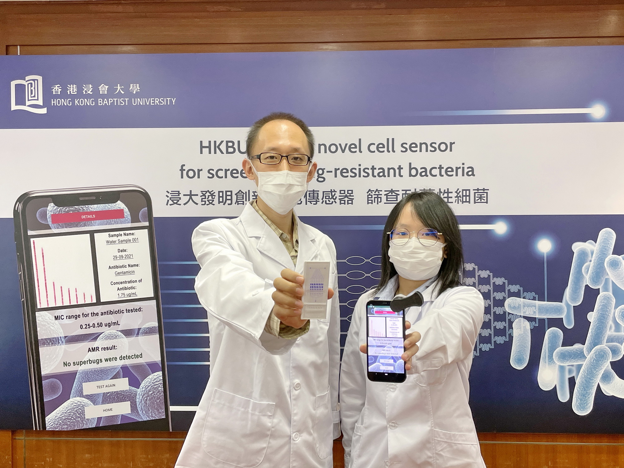 任康寧（左）表示，細胞傳感器配套手機App，掃描傳感器上的 「條碼」，就能以低成本快速篩查耐藥性細菌；旁為團隊成員化學系博士生陳昭穎。（蔡璿驩攝）