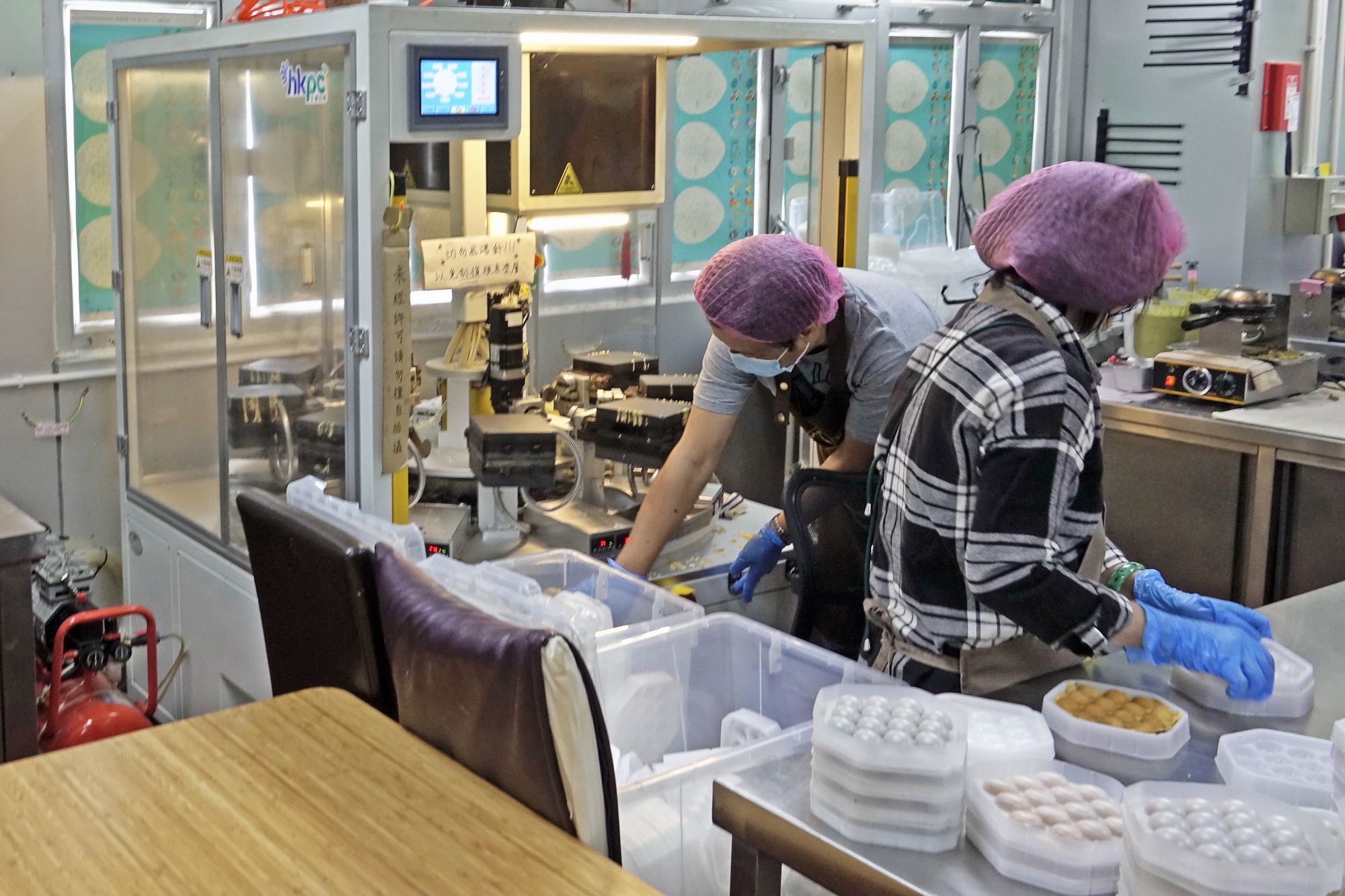 香港街食利用機器幫手生產急凍雞蛋仔，惟機器目前仍須依靠人手脫模、剪邊。（曾永超攝）