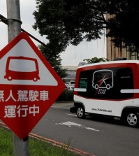 A sign reading 'Autonomous bus in operation' is seen next to a French-made 'EZ10' autonomous bus, also known as a driverless vehicle, as it runs at university campus in Taipei, Taiwan July 12, 2017. Picture taken July 12, 2017. REUTERS/Tyrone Siu