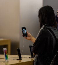 A customer uses the face recognition function on the 10th anniversary iPhone X in an Apple store in Hong Kong on November 3, 2017. / AFP PHOTO / ANTHONY WALLACE