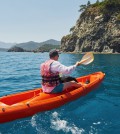 Boat kayaking near cliffs on a sunny day. Travel, sports concept. Lifestyle.